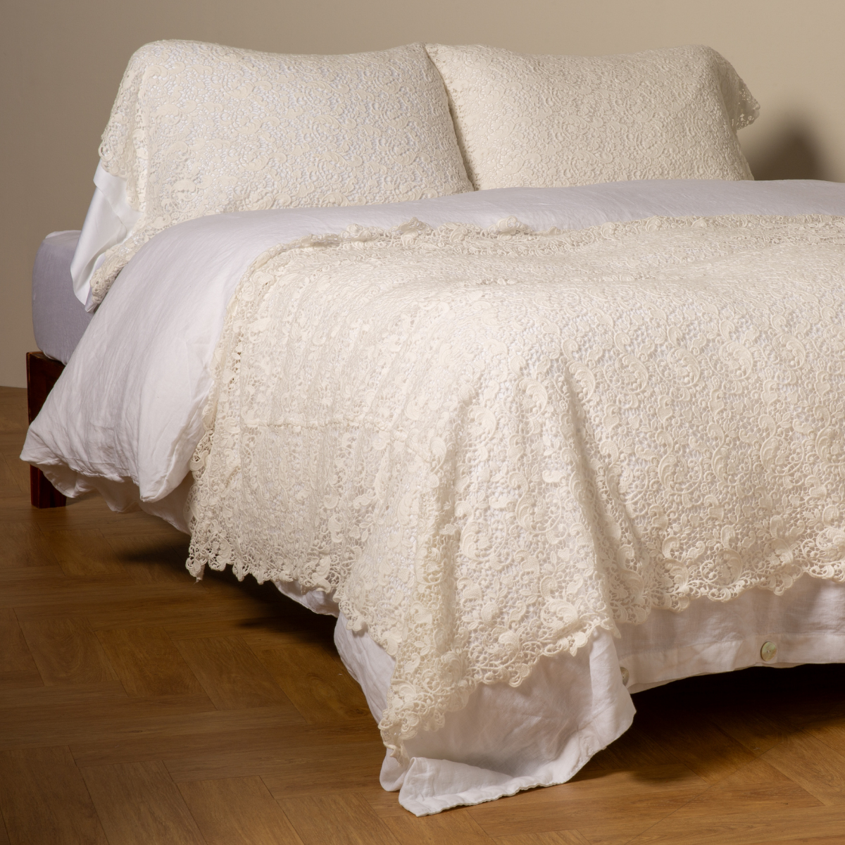 Winter White: cotton lace bed scarf draped across the foot of a bed dressed in linen sheets and duvet cover in winter white - shown with matching lace pillowcase covers over a linen liner in winter white.