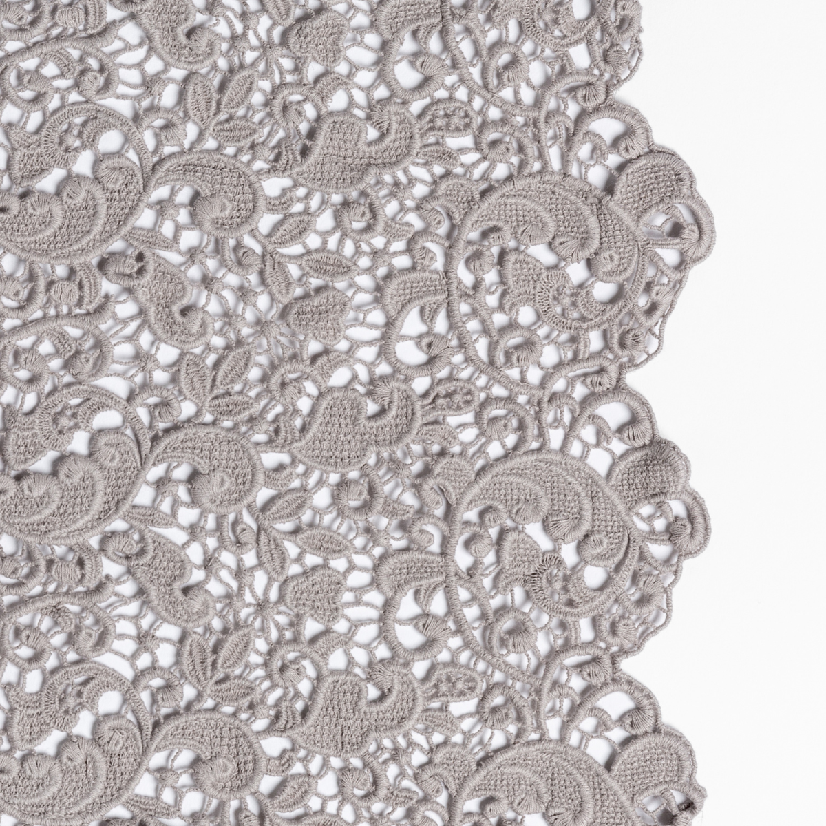 Fog: a close up of cotton all-over lace with a scalloped edge.