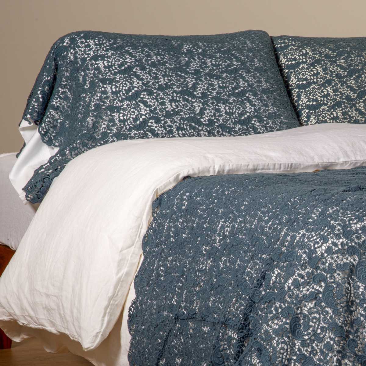 Midnight: a pair of cotton lace pillowcase covers on winter white liners shown on a bed dressed in winter white linen with a matching cotton lace bed scarf.
