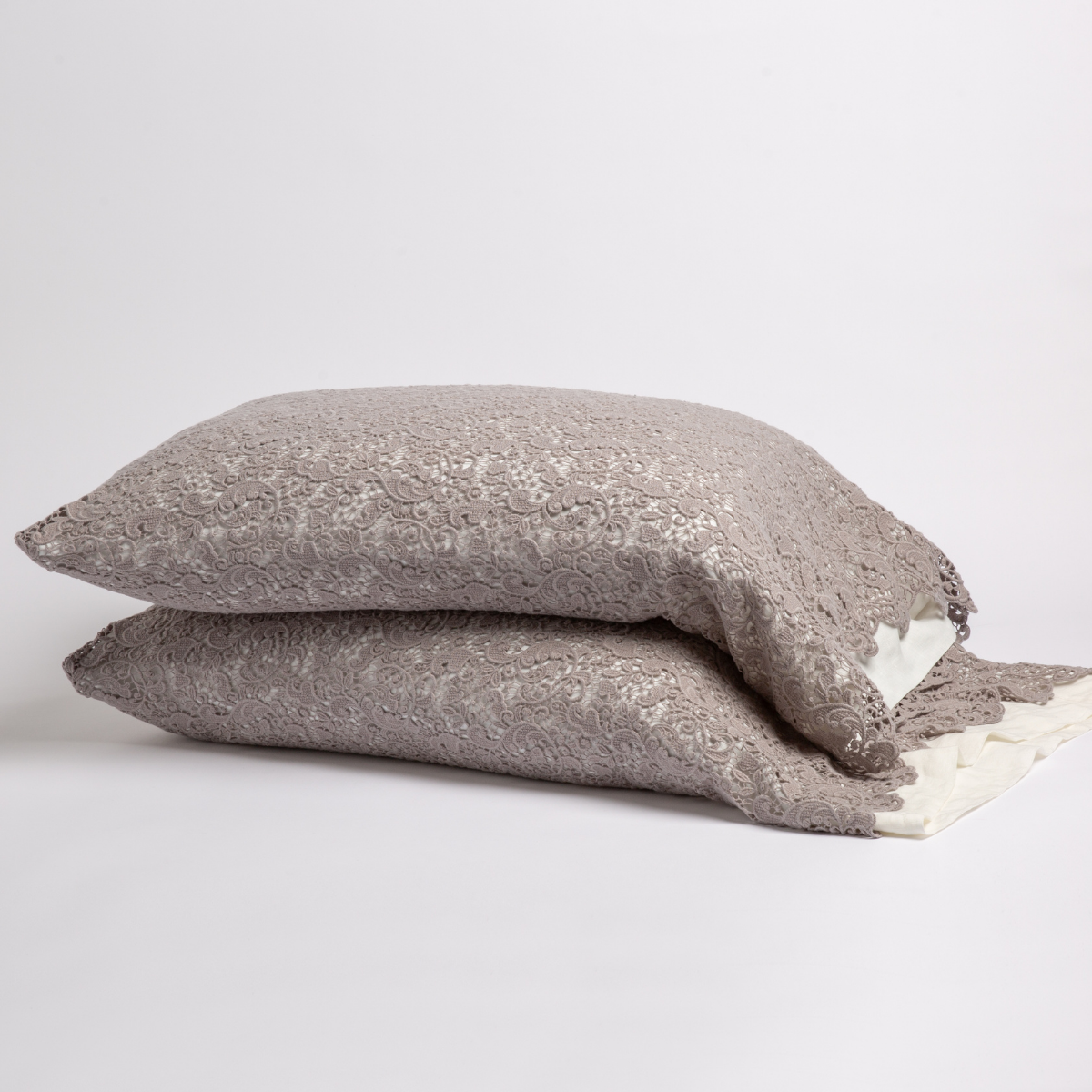 Moonlight: a pair of stacked cotton lace pillowcase covers on winter white liners against a white background.