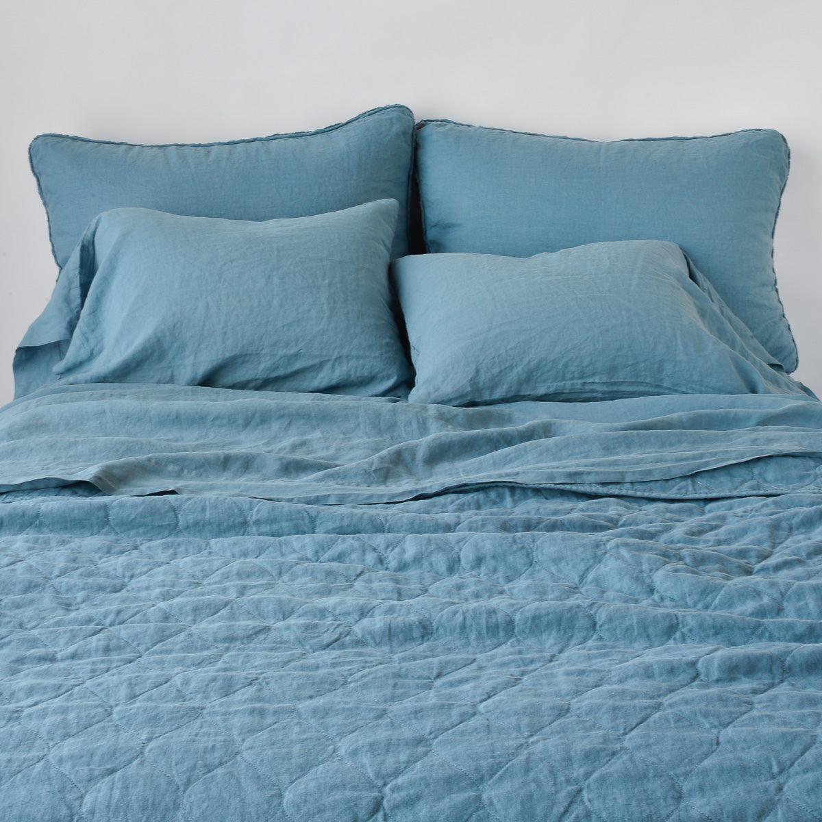 Cenote: Austin coverlet, end of bed view, with monochromatic sheeting and shams.