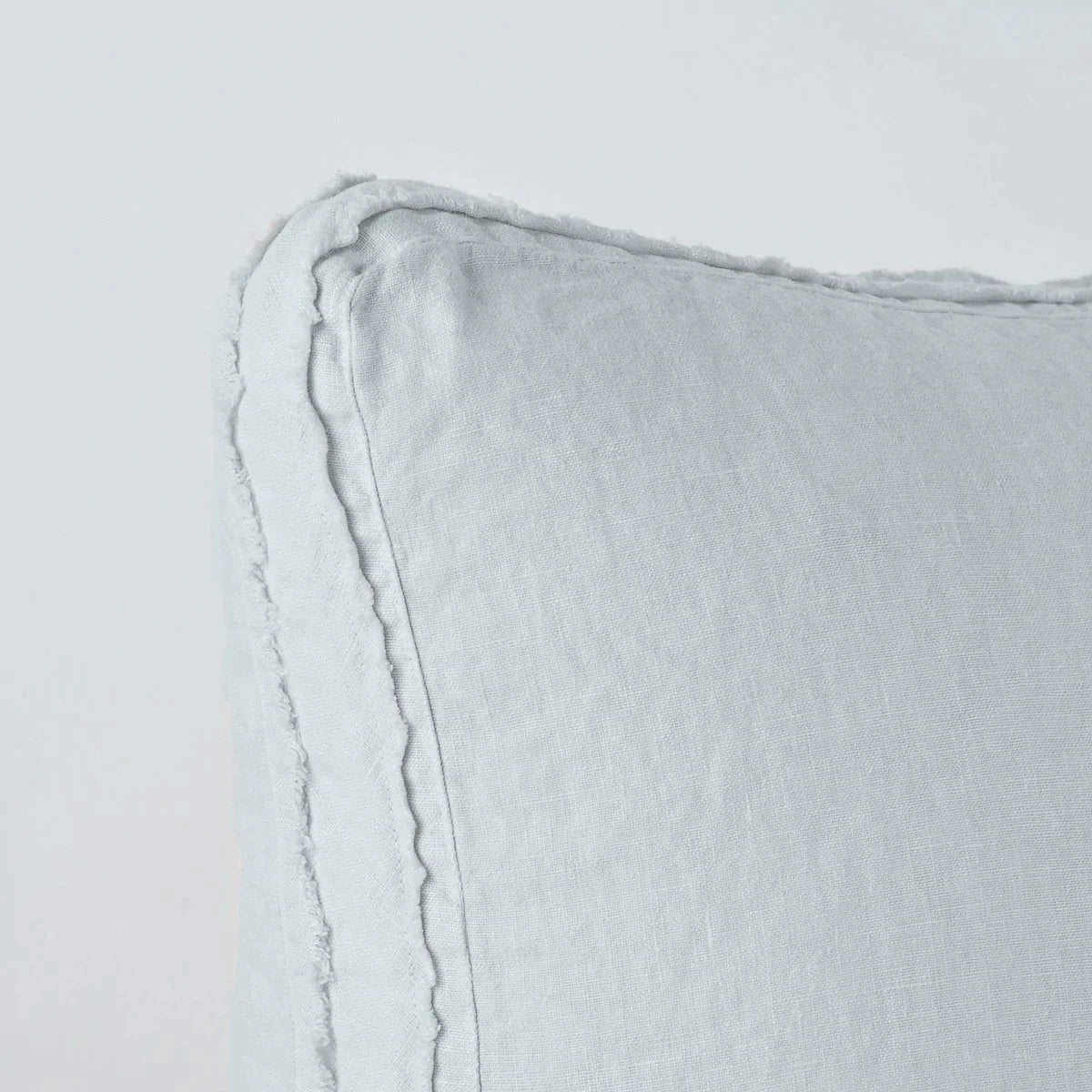 Cloud: Close-up angle of the corner of an Austin sham, highlighting the raw edge trim on either side of the gusset.