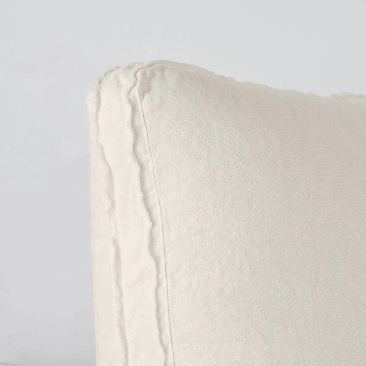 Parchment: Close-up angle of the corner of an Austin sham, highlighting the raw edge trim on either side of the gusset.