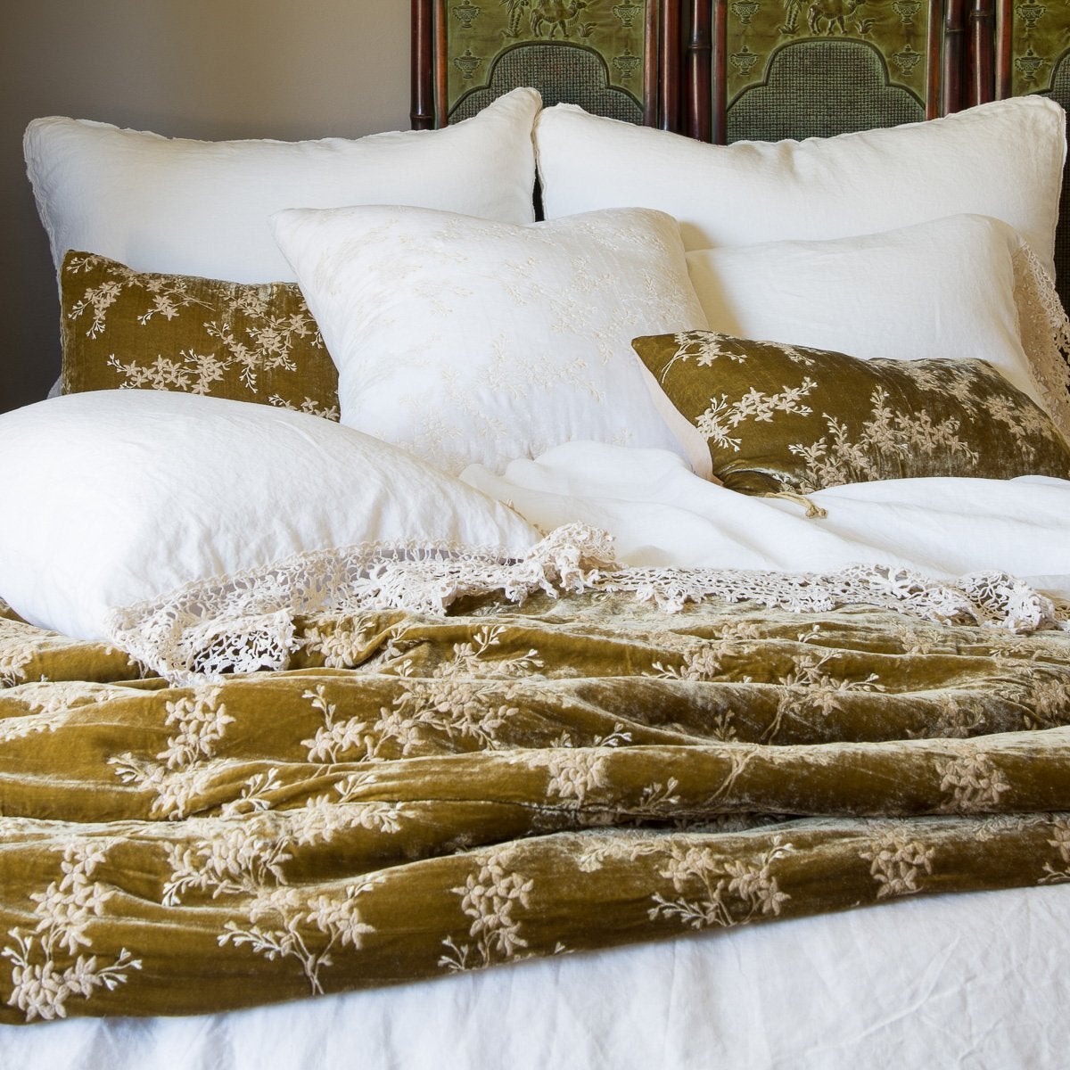 : Winter white bed with honeycomb accents, highlighting how Frida antique cotton lace can be layered with embroidered silk velvet - cropped view from end of bed.