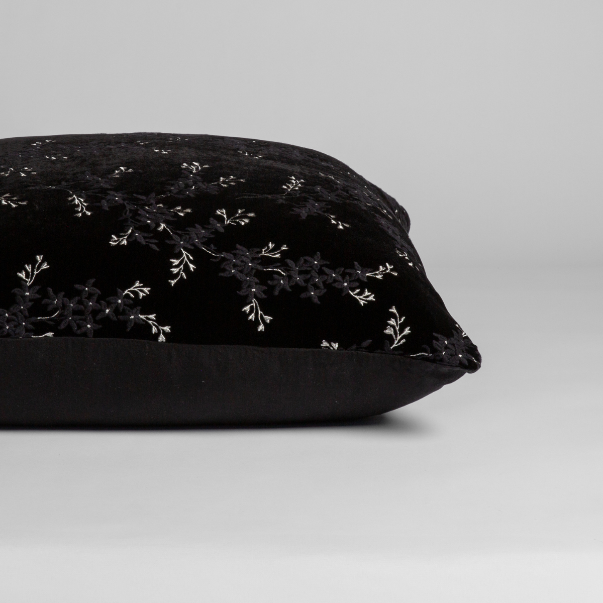 Corvino: A close-up of the sham shown on its side to display the embroidered silk velvet face and tencel back — shown against a white background.