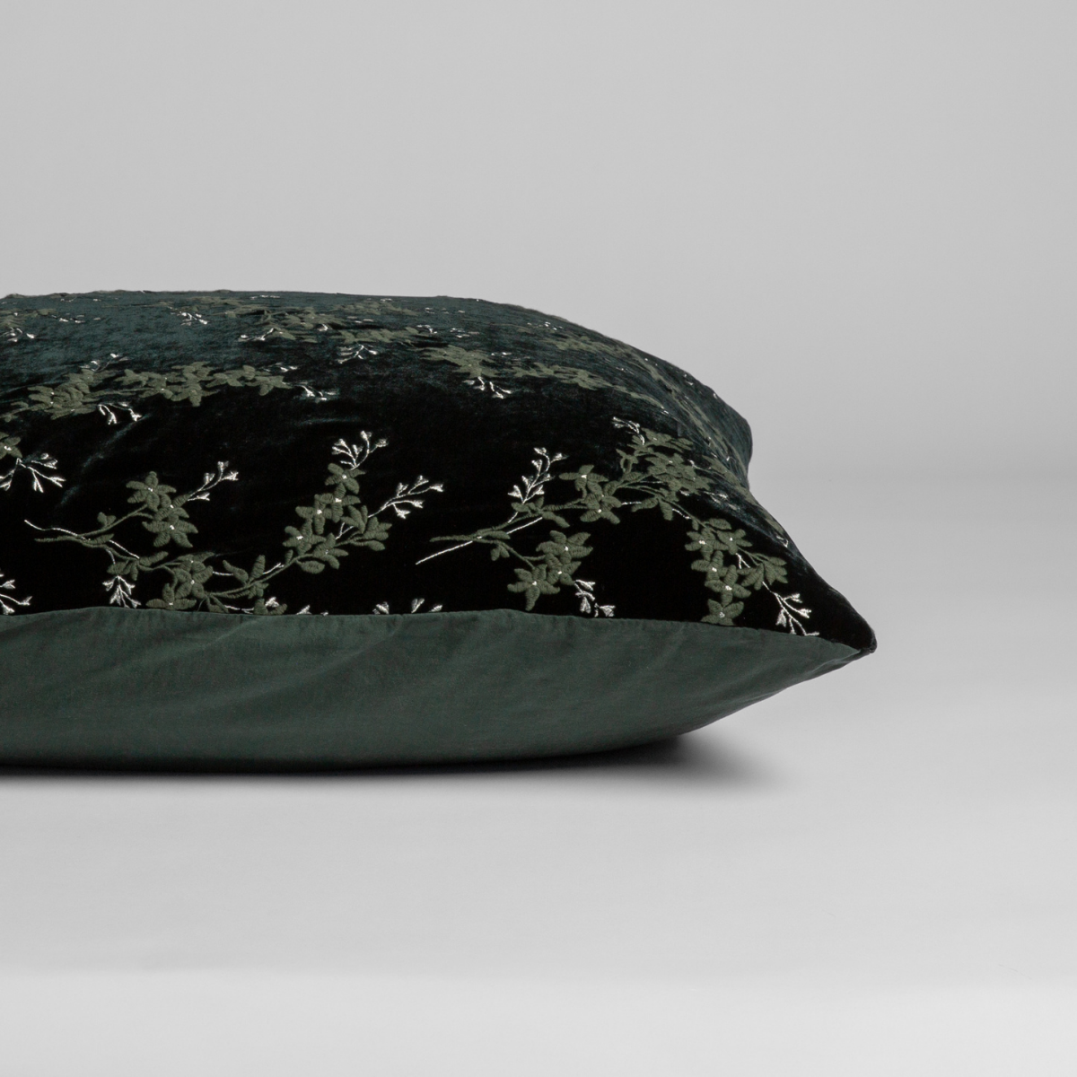 Juniper: A close-up of the sham shown on its side to display the embroidered silk velvet face and tencel back — shown against a white background.