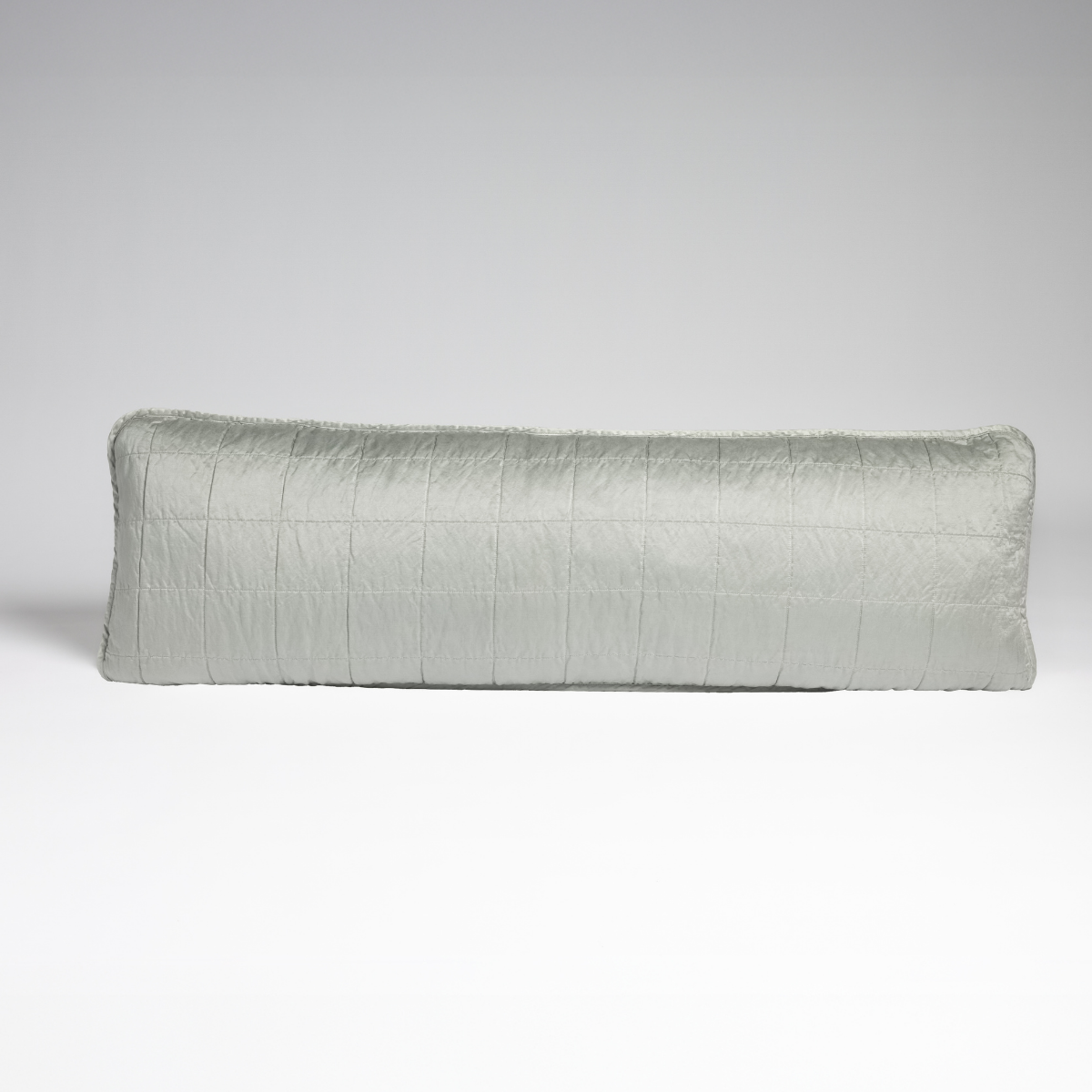 Eucalyptus: A straight-on shot of a square-quilted body pillow in eucalyptus, a soft light green, against a white background.