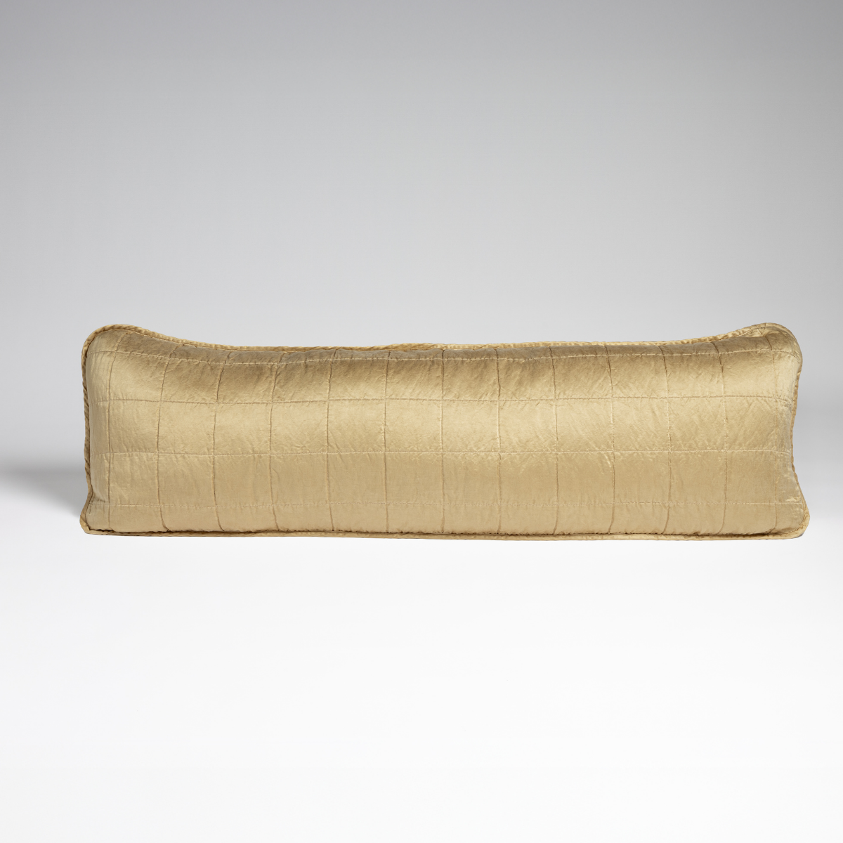 Honeycomb: A straight-on shot of a square-quilted body pillow in honeycomb, a warm golden tone, against a white background.