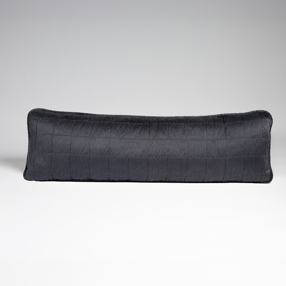 Midnight: A straight-on shot of a square-quilted body pillow in midnight, a rich indigo tone, against a white background.
