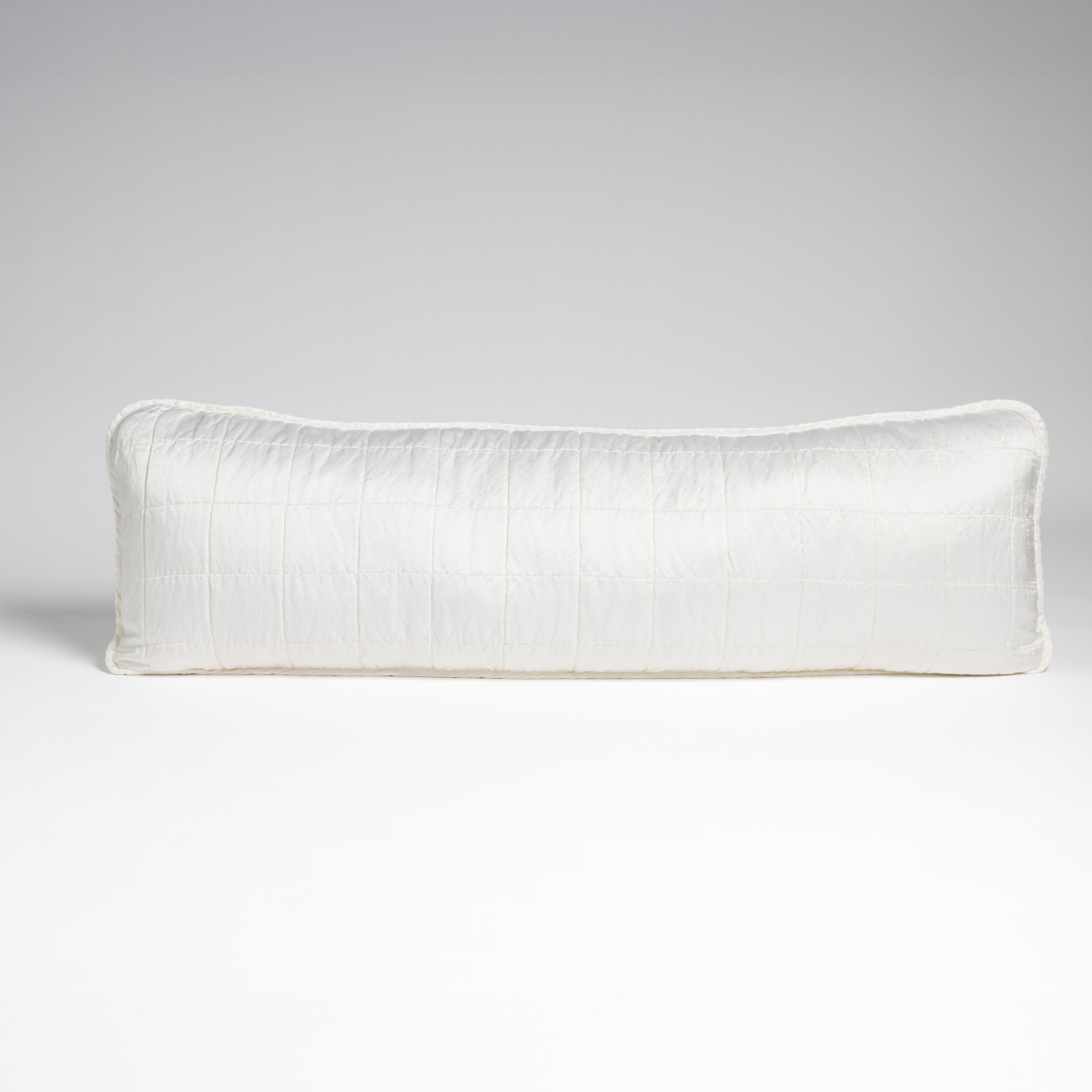 White: A straight-on shot of a square-quilted body pillow in classic white, against a white background.
