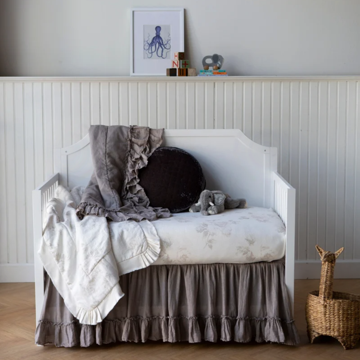 : Crib sheet and blanket shown with dark grey accents highlights the subtle floral printed linen.