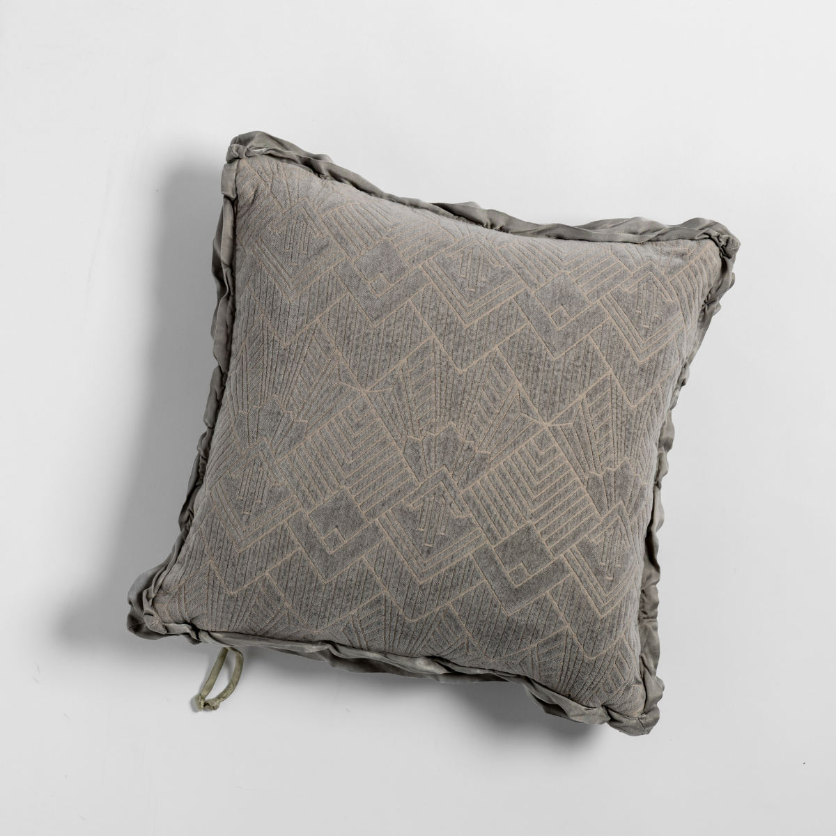 Fog: The chenille side of a textured throw pillow with contrasting ruffled edges, shot from overhead against a plain background.