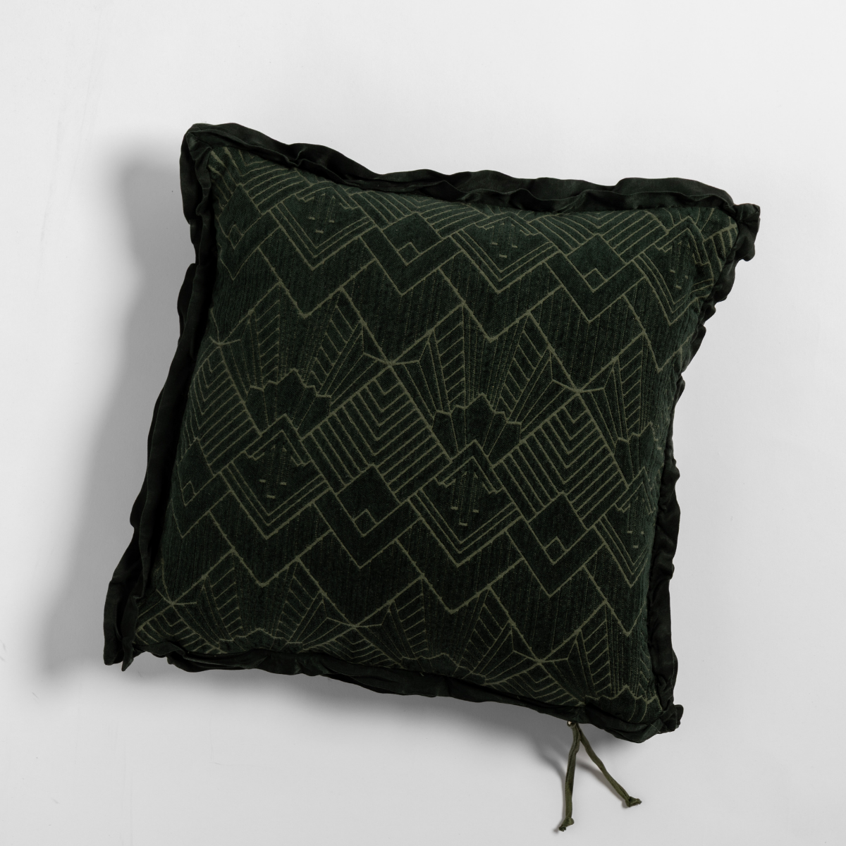 Juniper: The chenille side of a textured throw pillow with contrasting ruffled edges, shot from overhead against a plain background.