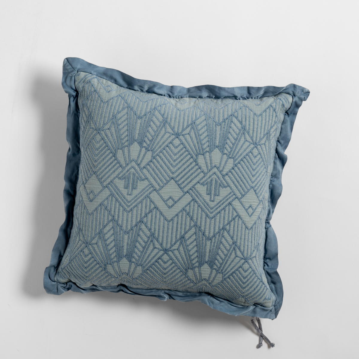 Tahoe Blue: The cotton jacquard side of a textured throw pillow with contrasting ruffled edges, shot from overhead against a plain background.
