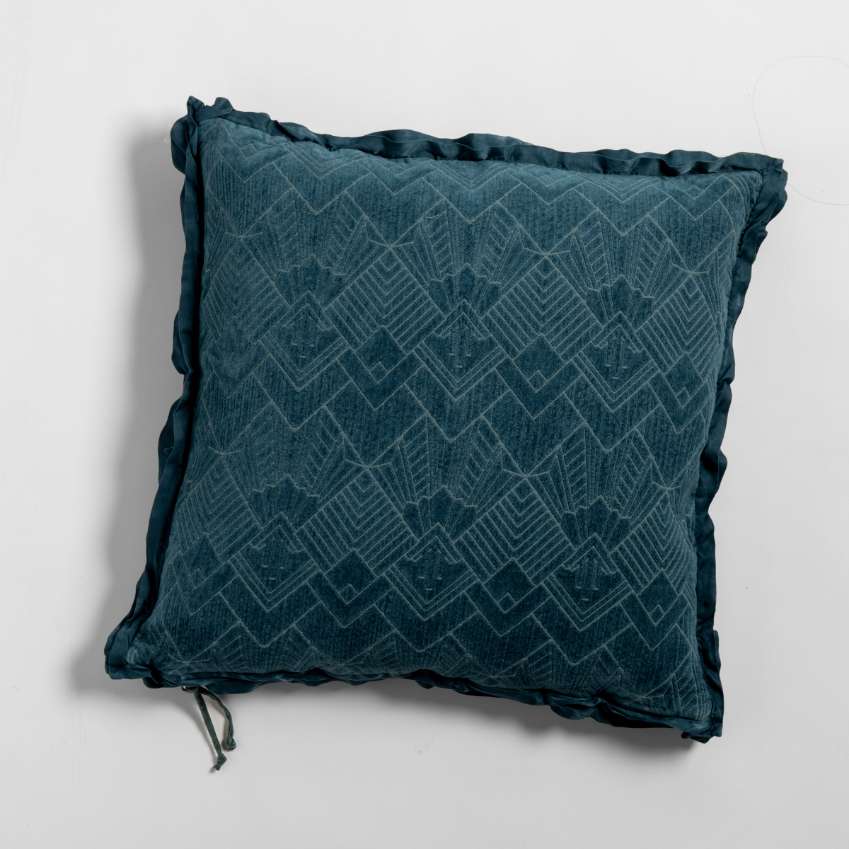 Cenote: The chenille side of a textured throw pillow with contrasting ruffled edges, shot from overhead against a plain background.