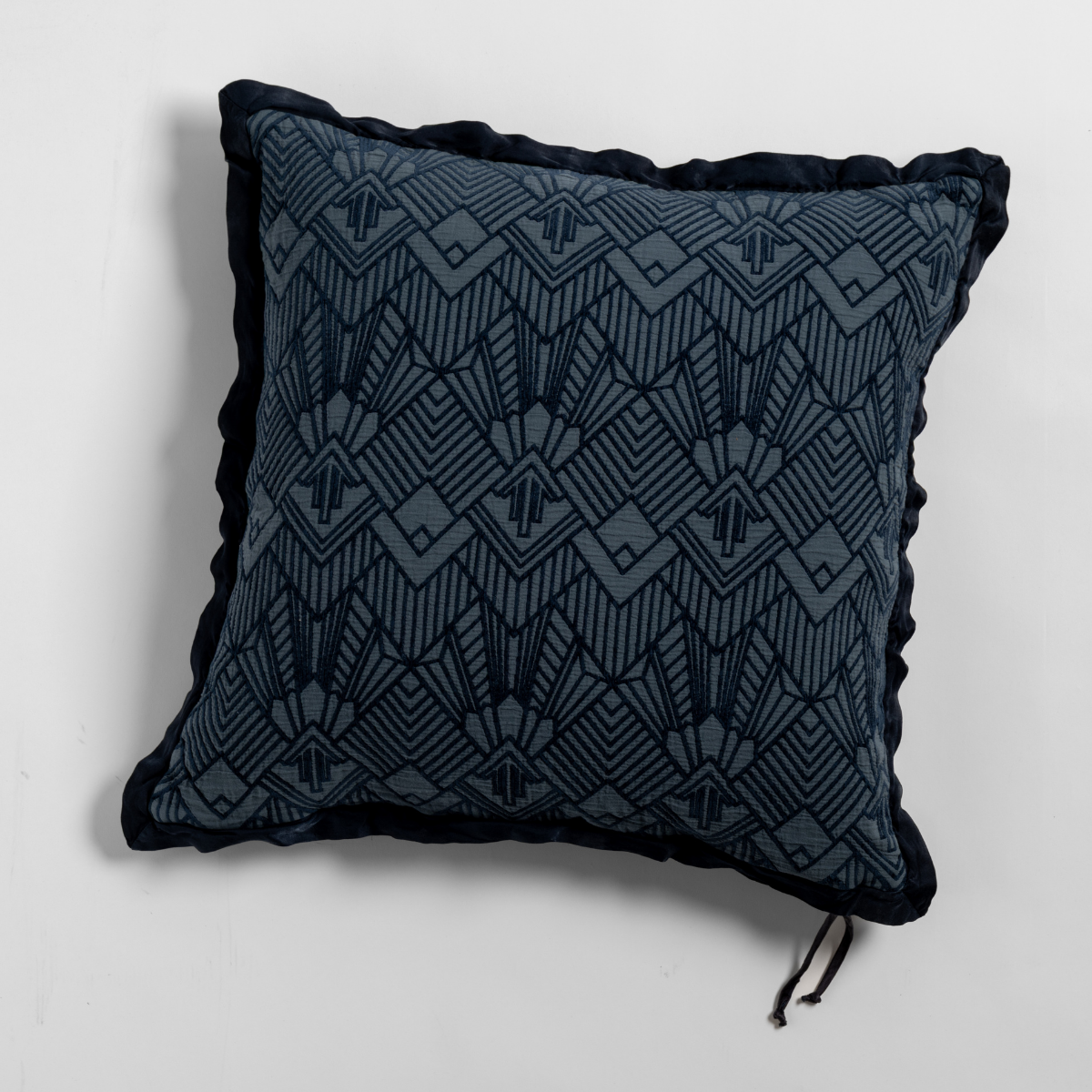 Midnight: The cotton jacquard side of a textured throw pillow with contrasting ruffled edges, shot from overhead against a plain background.