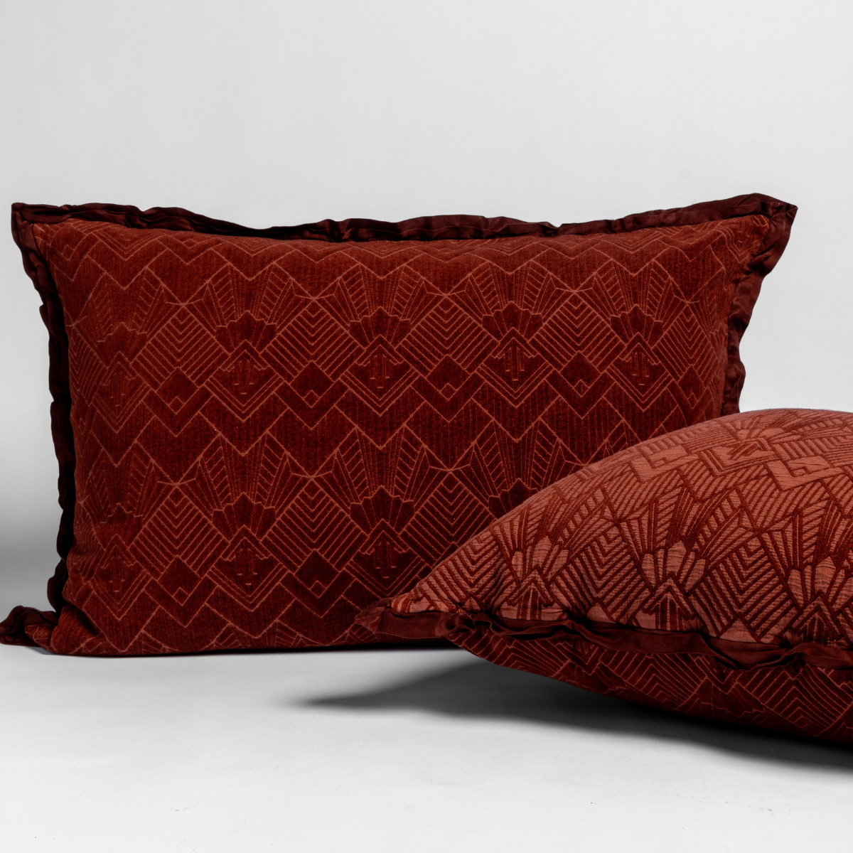 Autumn: Two art deco patterned shams, one upright and one on its side, against a plain background.