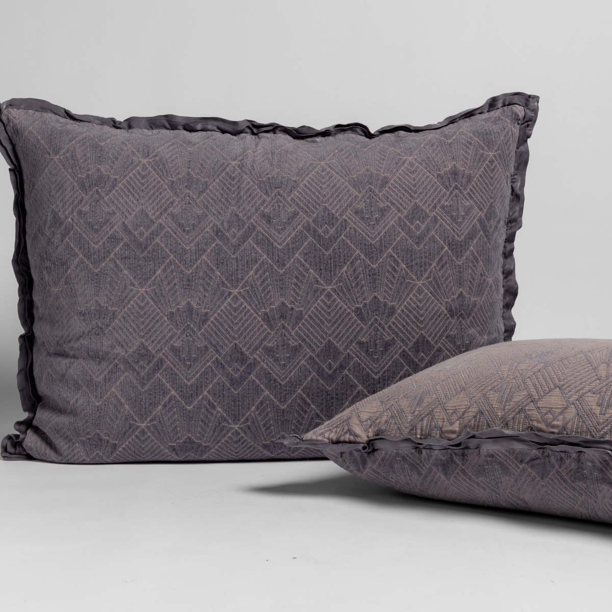 French Lavender: Two art deco patterned shams, one upright and one on its side, against a plain background.