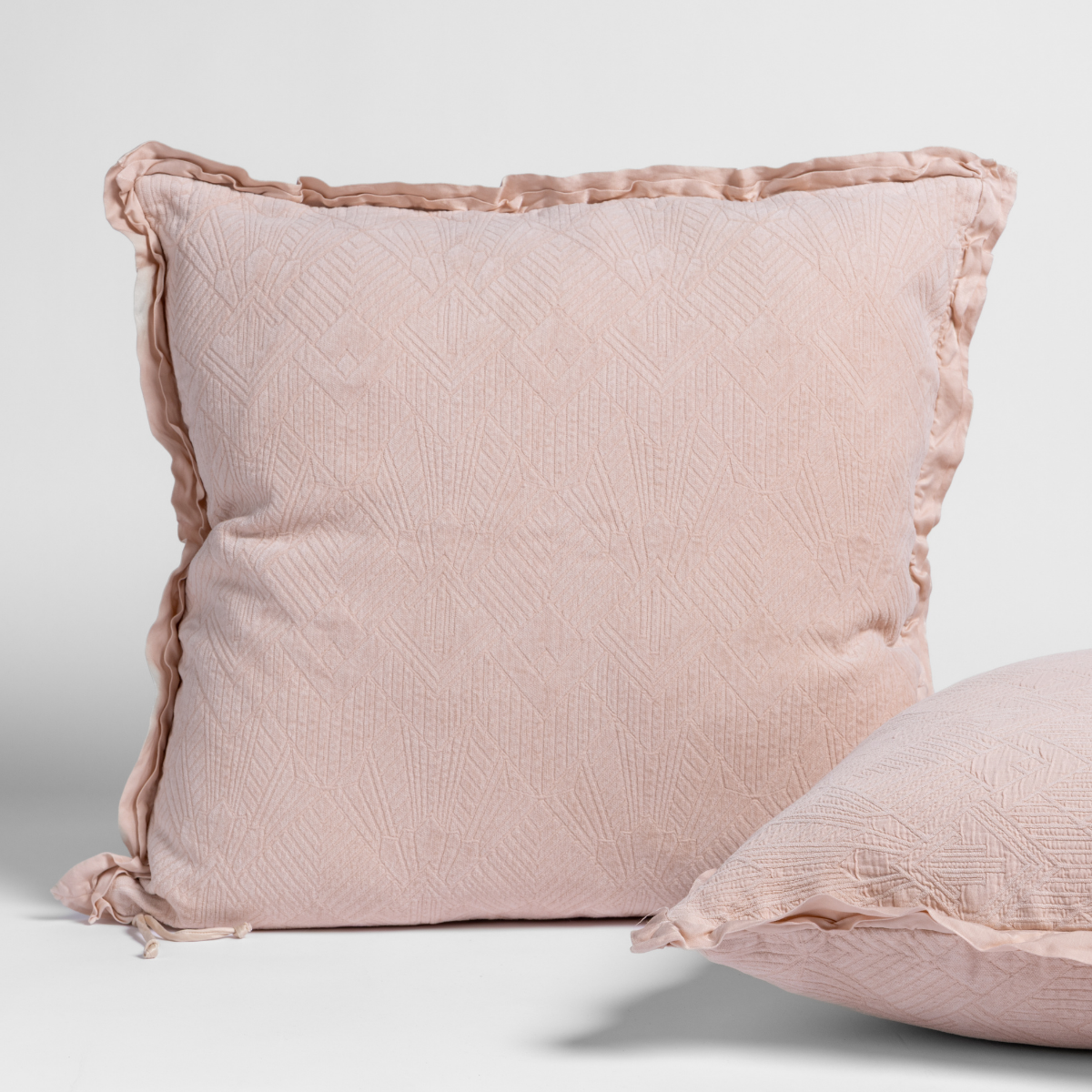 Pearl: Two art deco patterned shams, one upright and one on its side, against a plain background.