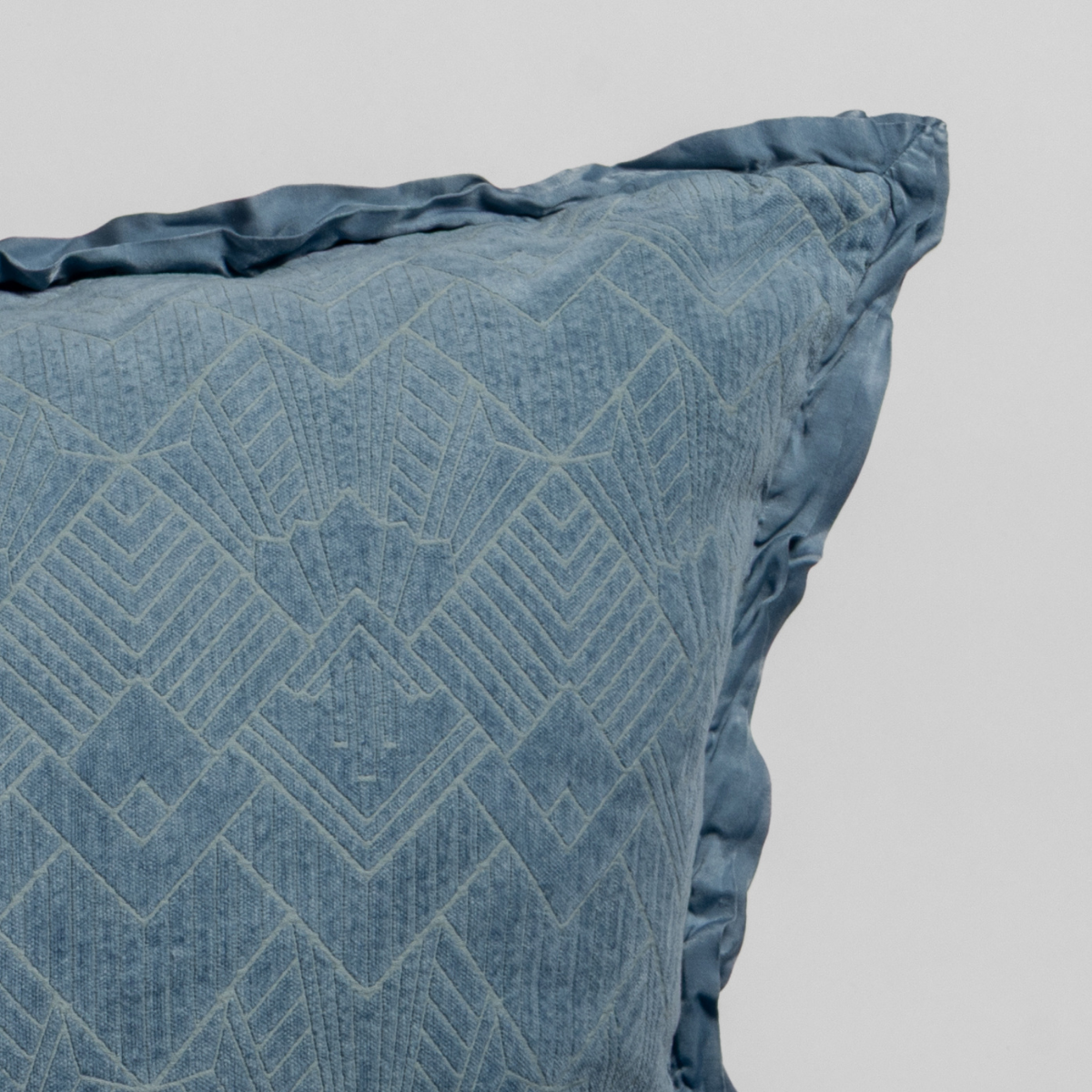 Tahoe Blue: Close-up of a textured pillow sham corner with a satin ruffle, shot against a plain background.