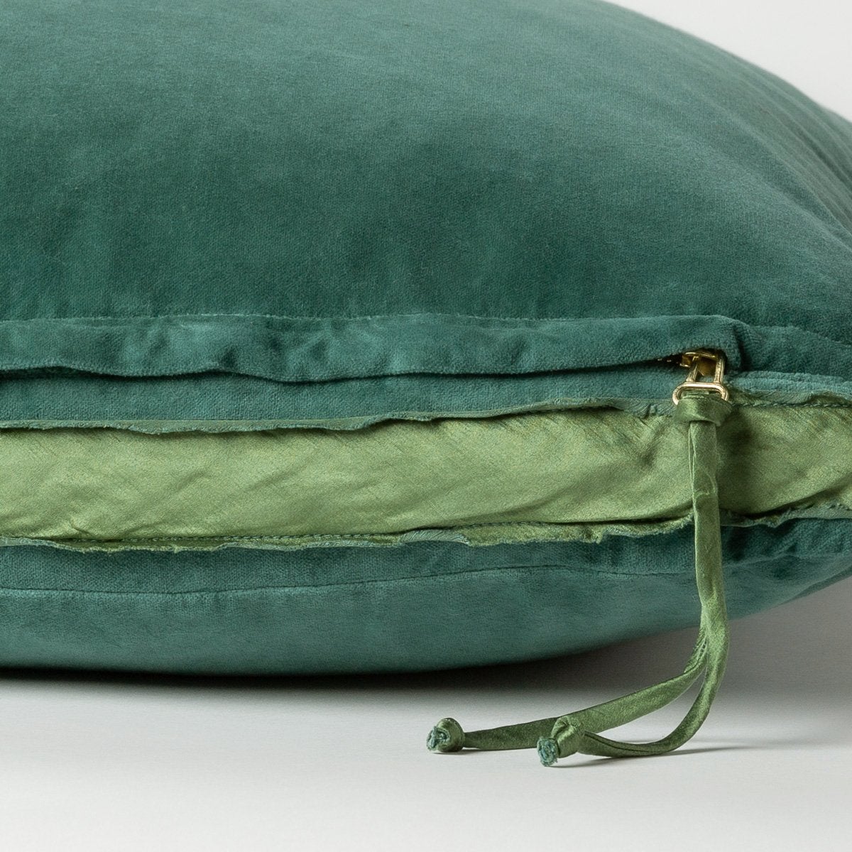 Jade: Close-up of charmeuse gusset, raw-edge trim, and brass zipper detail on cotton velvet sham - side view.