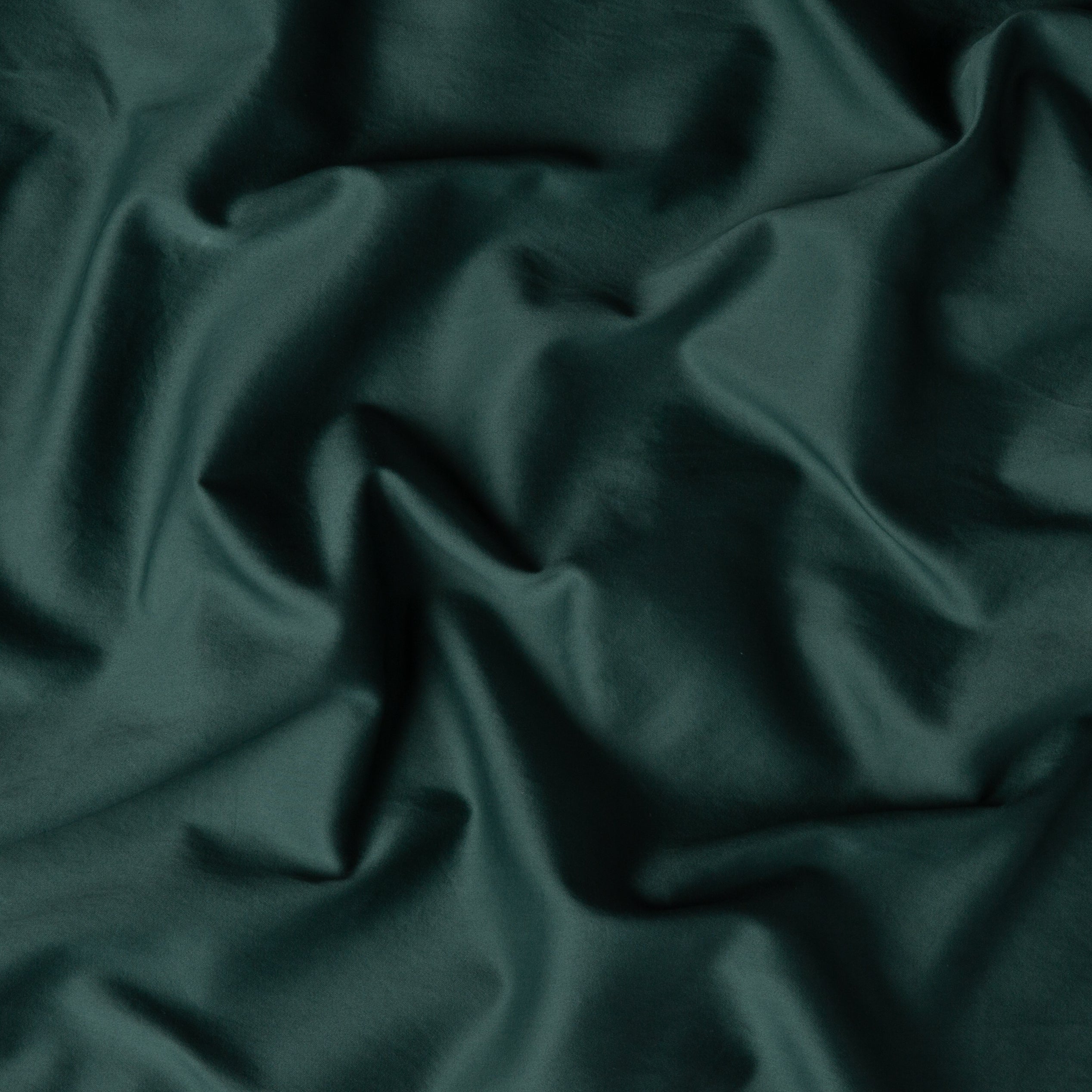 A close up of cotton sateen fabric in jade, a rich, verdant green with subtle blue undertones.