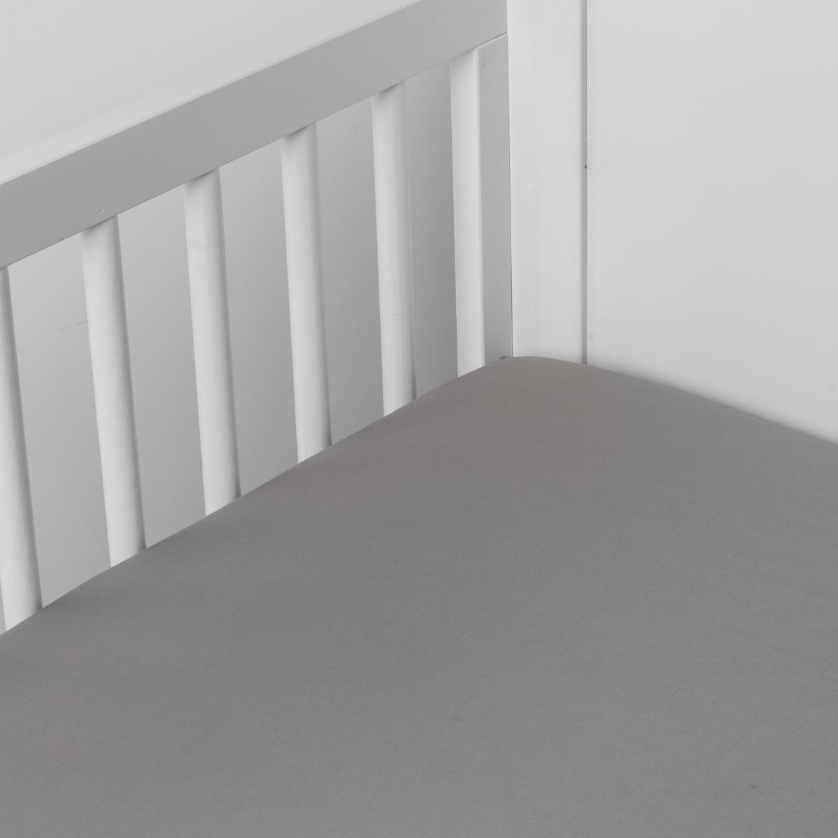 Mineral: Cotton sateen crib sheet shown from a slight overhead angle into an inside corner of a crib.