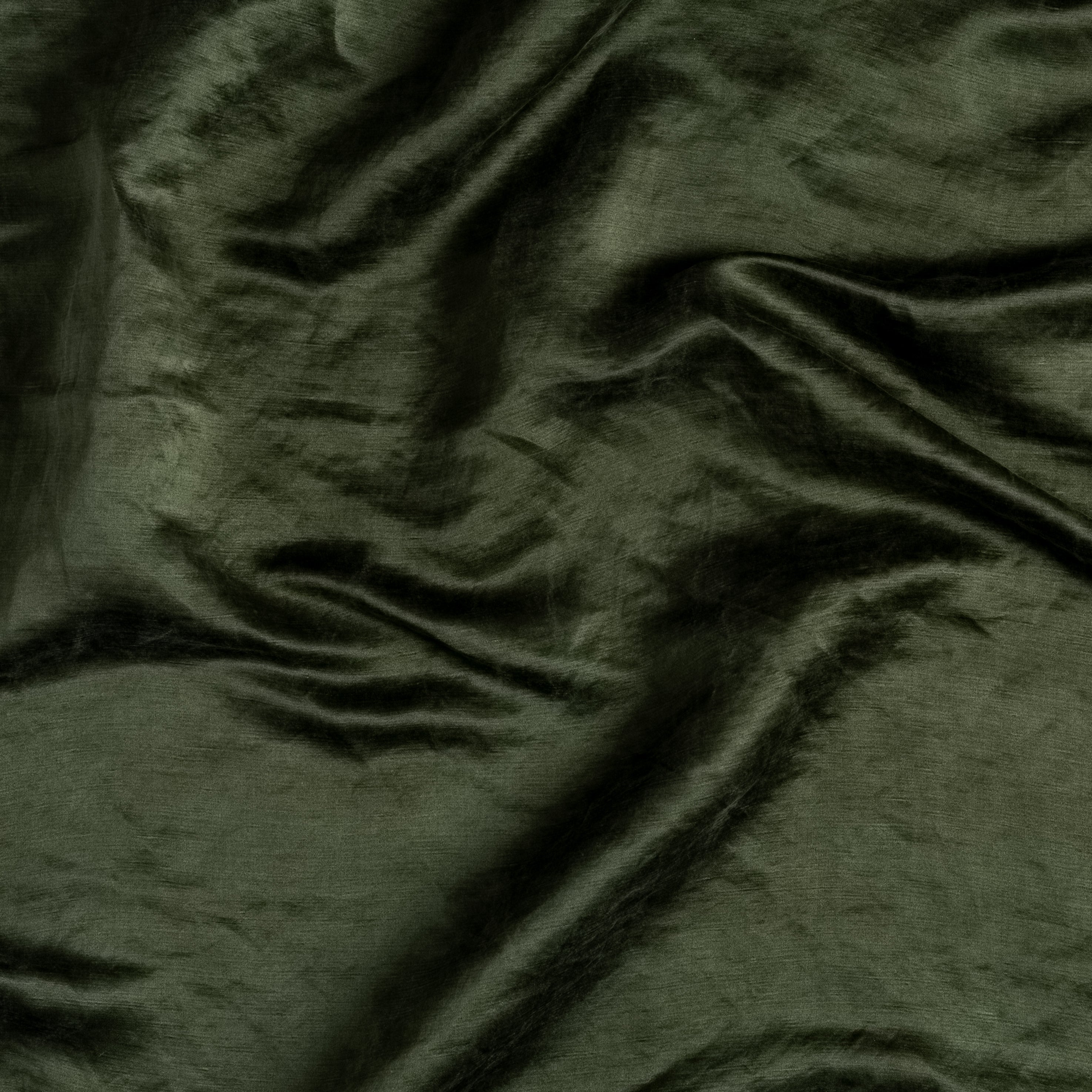 A close up of gently rumpled charmeuse in juniper, a deep green tone.