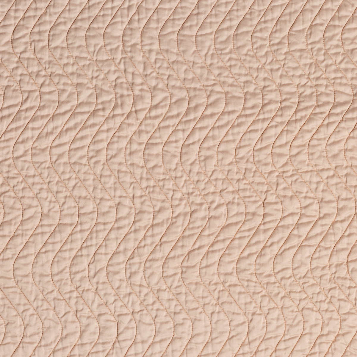 Pearl: A close up of quilted cotton sateen fabric in pearl, a nude-like, soft rose pink tone.