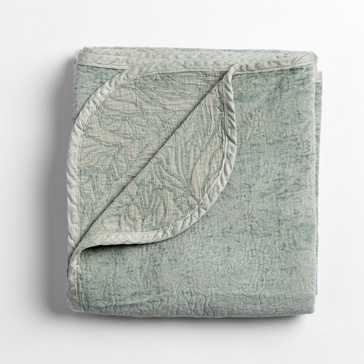 Eucalyptus: folded blanket with its cotton jacquard side visible on the corner foldback against the chenille jacquard side.
