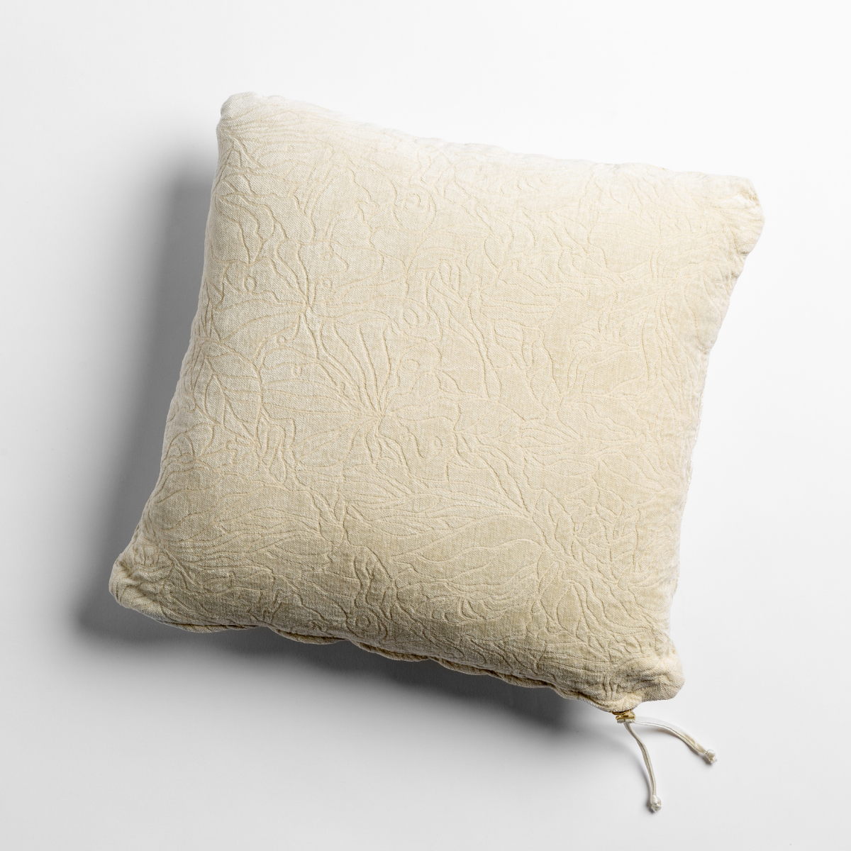 Parchment: chenille jacquard side of a georgia square cushion shown from overhead against a white background.