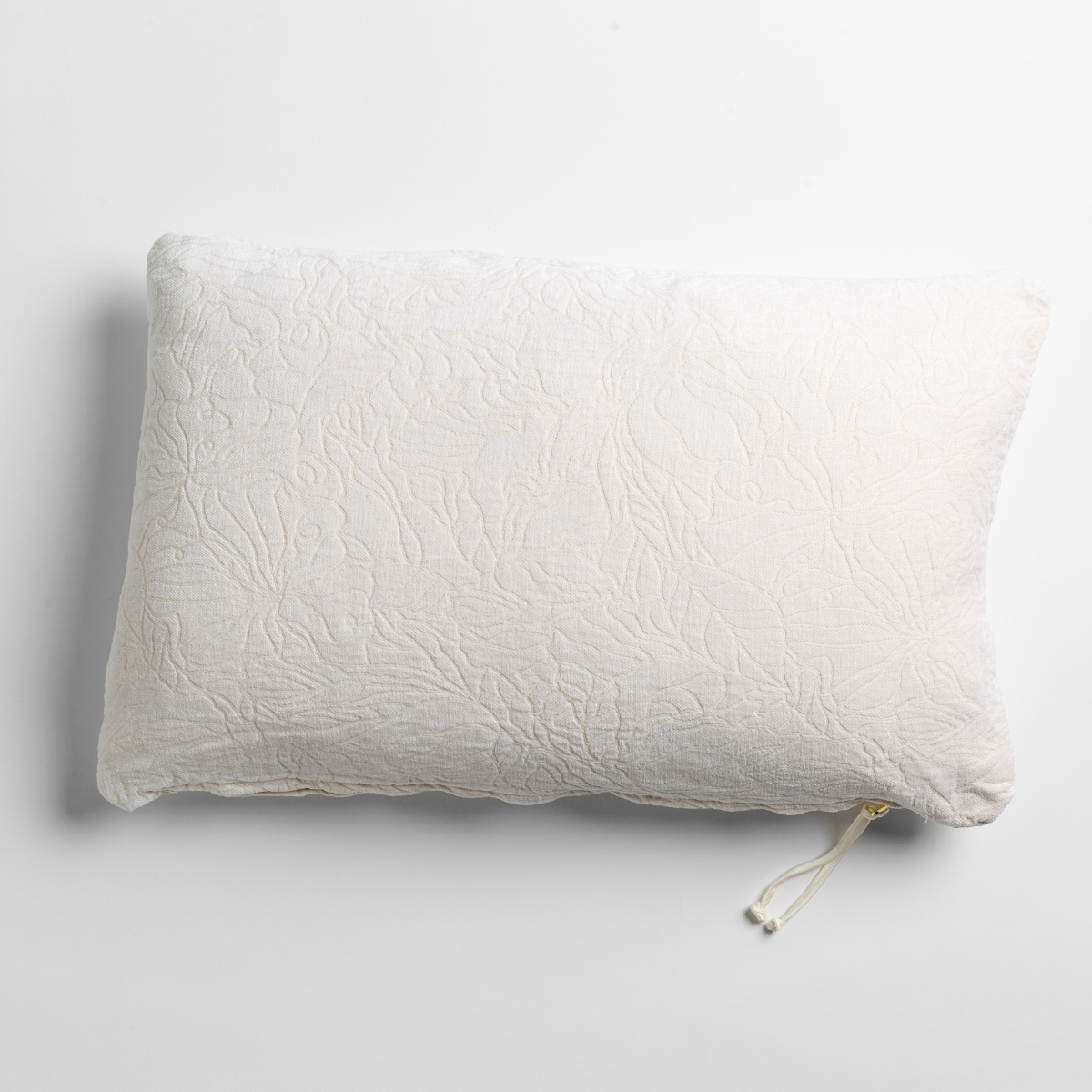 Winter White: chenille jacquard side of a rectangle throw pillow shown from overhead against a white background.