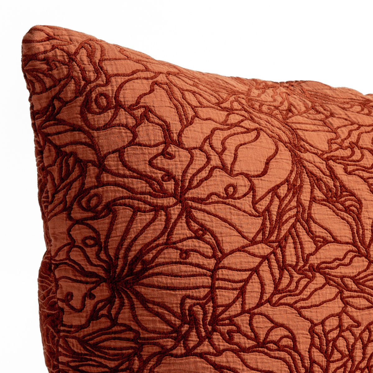 Autumn: A close-up of the corner of a Georgia cushion with the cotton jacquard side in Autumn, a rich terracotta tone, shown against a white background.