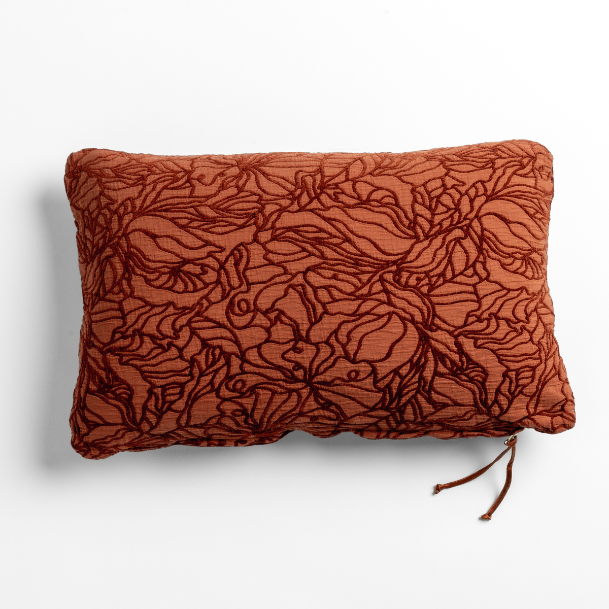 Autumn: A close-up of a cotton jacquard side of a Georgia Throw Pillow in Autumn, a rich terracotta tone, shown against a white background.