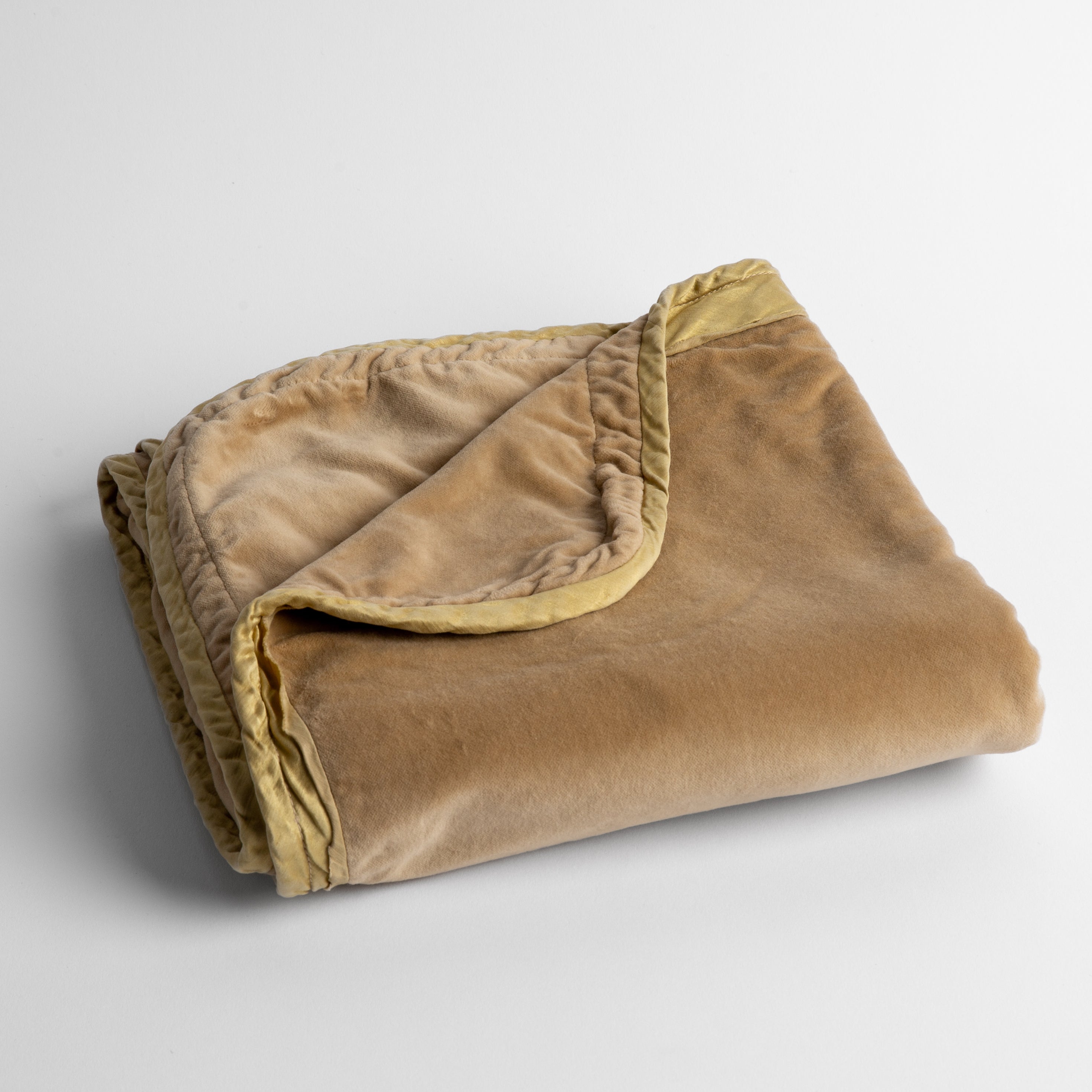Honeycomb: cotton velvet baby blanket trimmed with charmeuse, folded with a covern folded back to show trim contrast; shot overhead and at a slight angle against a white background.