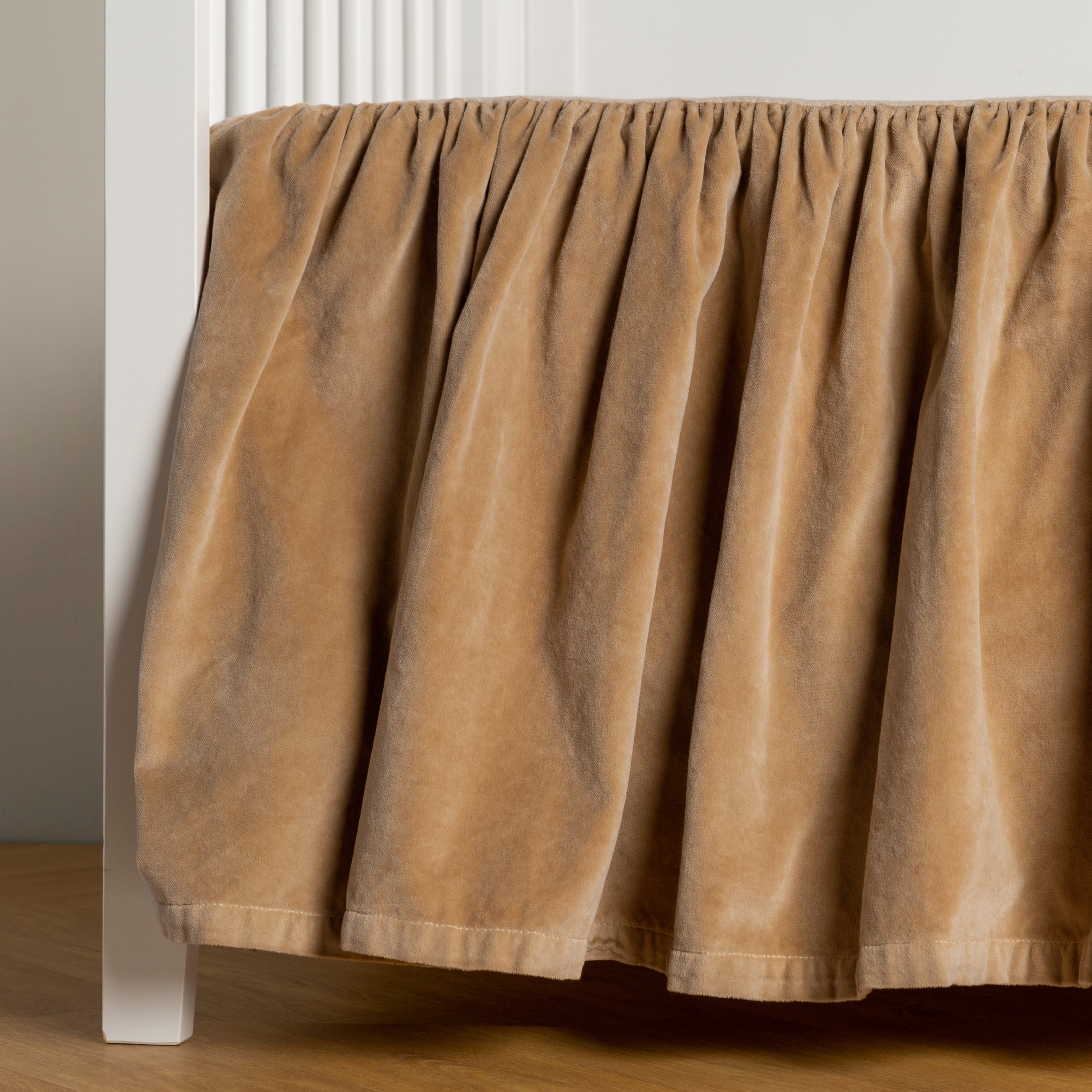Honeycomb: cotton velvet crib skirt shown on a white crib .