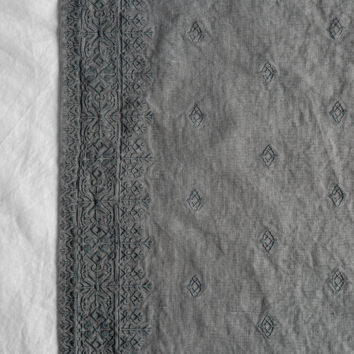 Moonlight: A close up of Ines, midweight linen with cotton embroidery, in white.