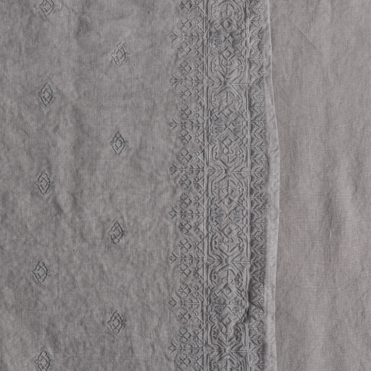 Moonlight: A close up of embroidered midweight linen fabric in moonlight, a saturated, cool, mid-dark grey tone.