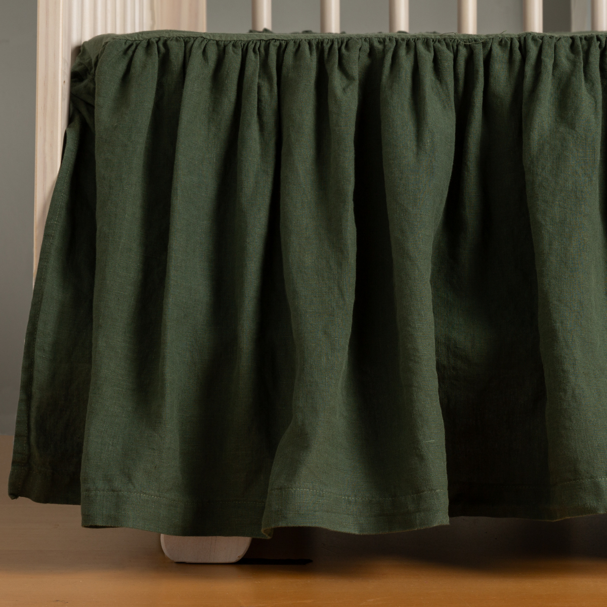 Juniper: linen crib skirt shown on a crib without a crib matress.