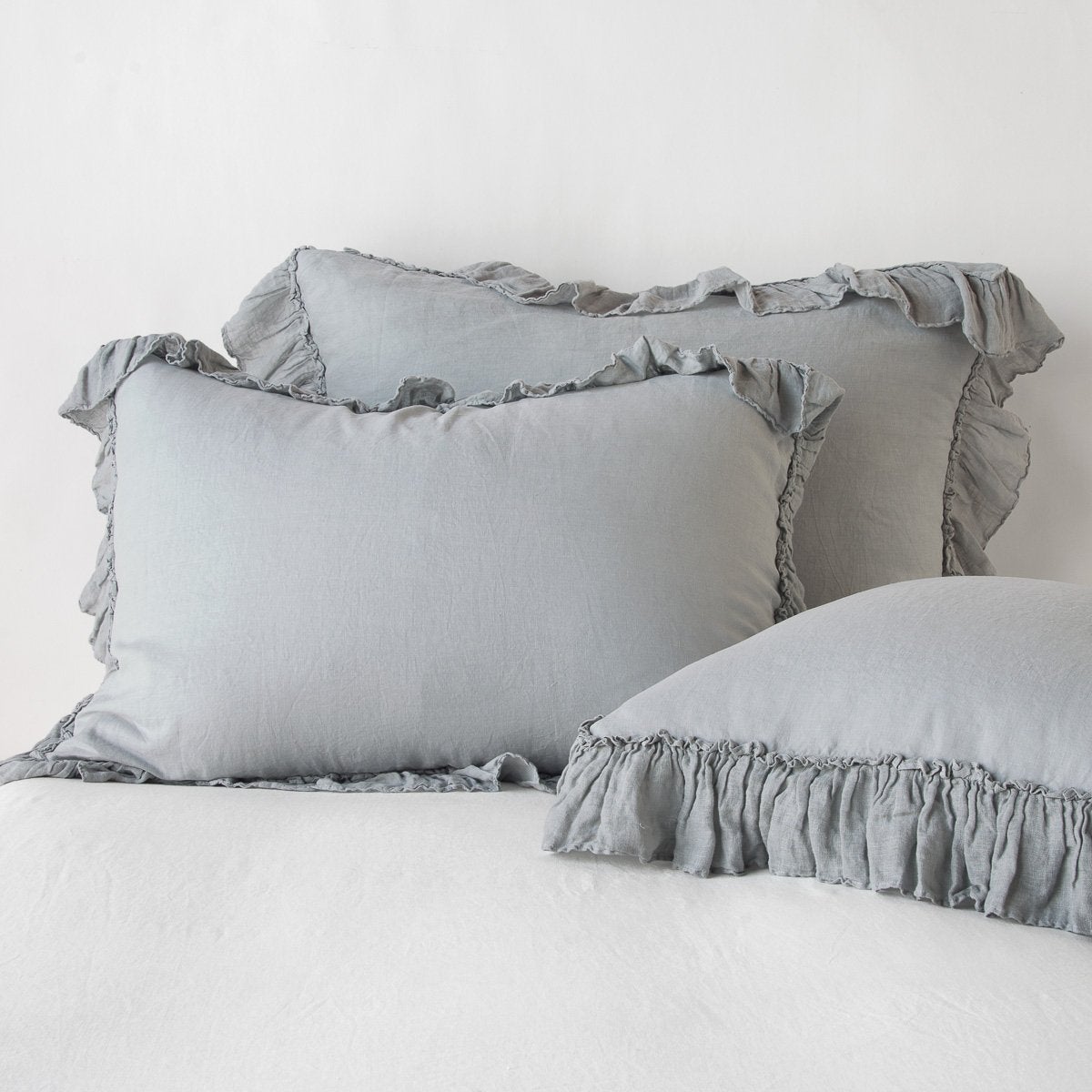 Mineral: two shams leaning upright and one laying flat at an angle in the foreground, against a blank background.