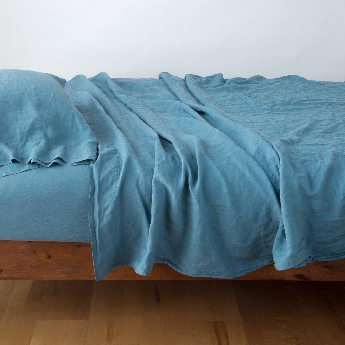 Cenote: sleeping pillow with matching rumpled sheeting - side view.