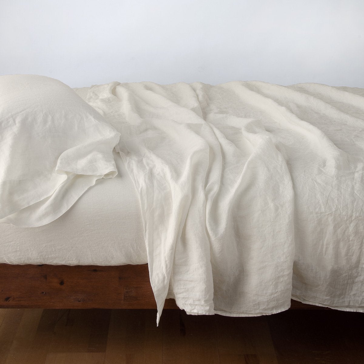 Parchment: sleeping pillow with matching rumpled sheeting - side view.