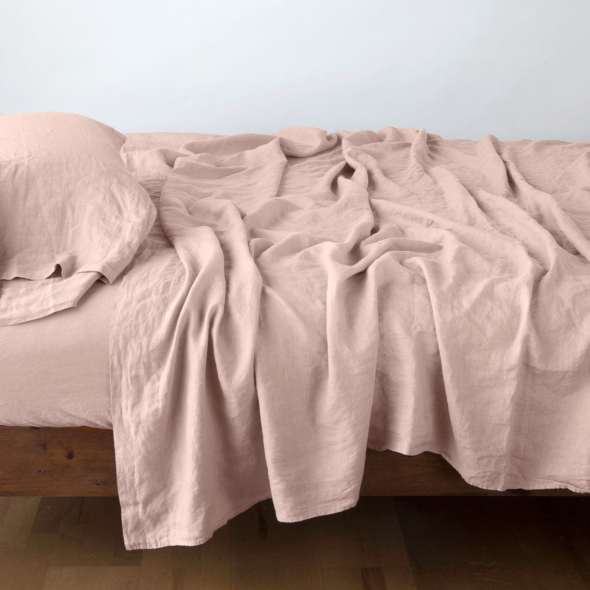 Rouge: sleeping pillow with matching rumpled sheeting - side view.