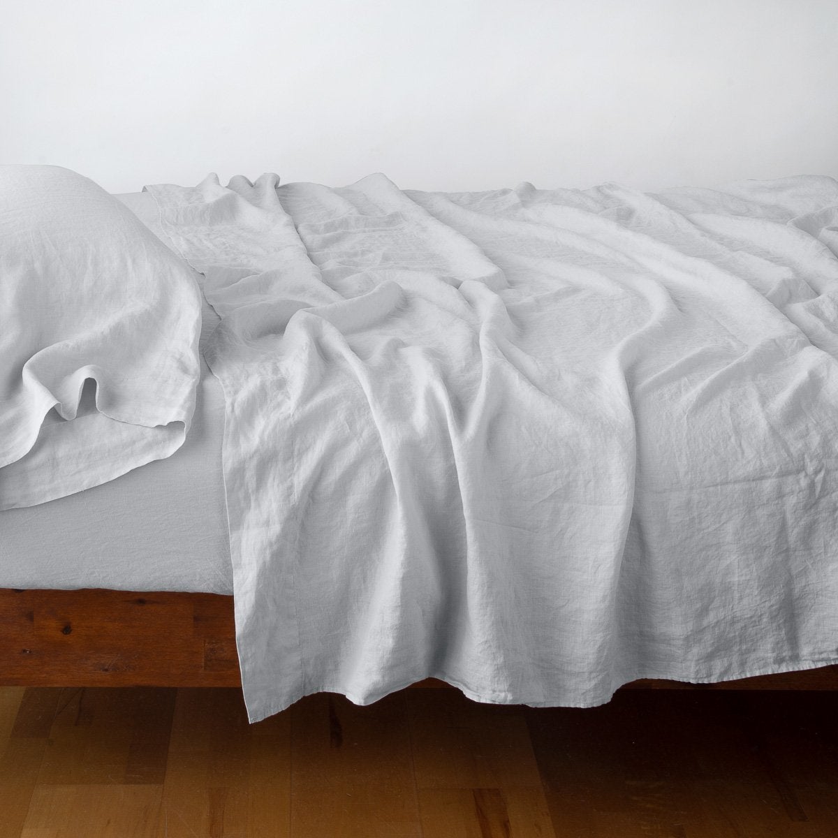 Sterling: sleeping pillow with matching rumpled sheeting - side view.