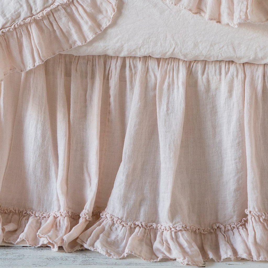 Pearl: Close-up of crib skirt, lightly puddled on distressed wood floor, showcasing ruffle detail.
