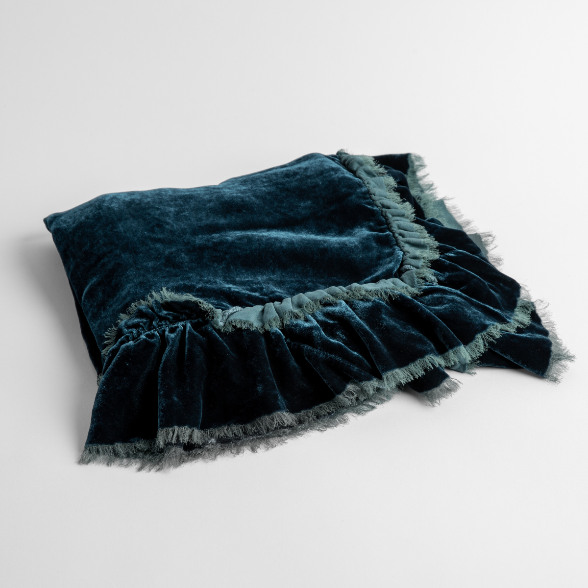 Cenote: an overhead shot of a folded silk velvet baby blanket with a raw-edged eyelash ruffle detail.