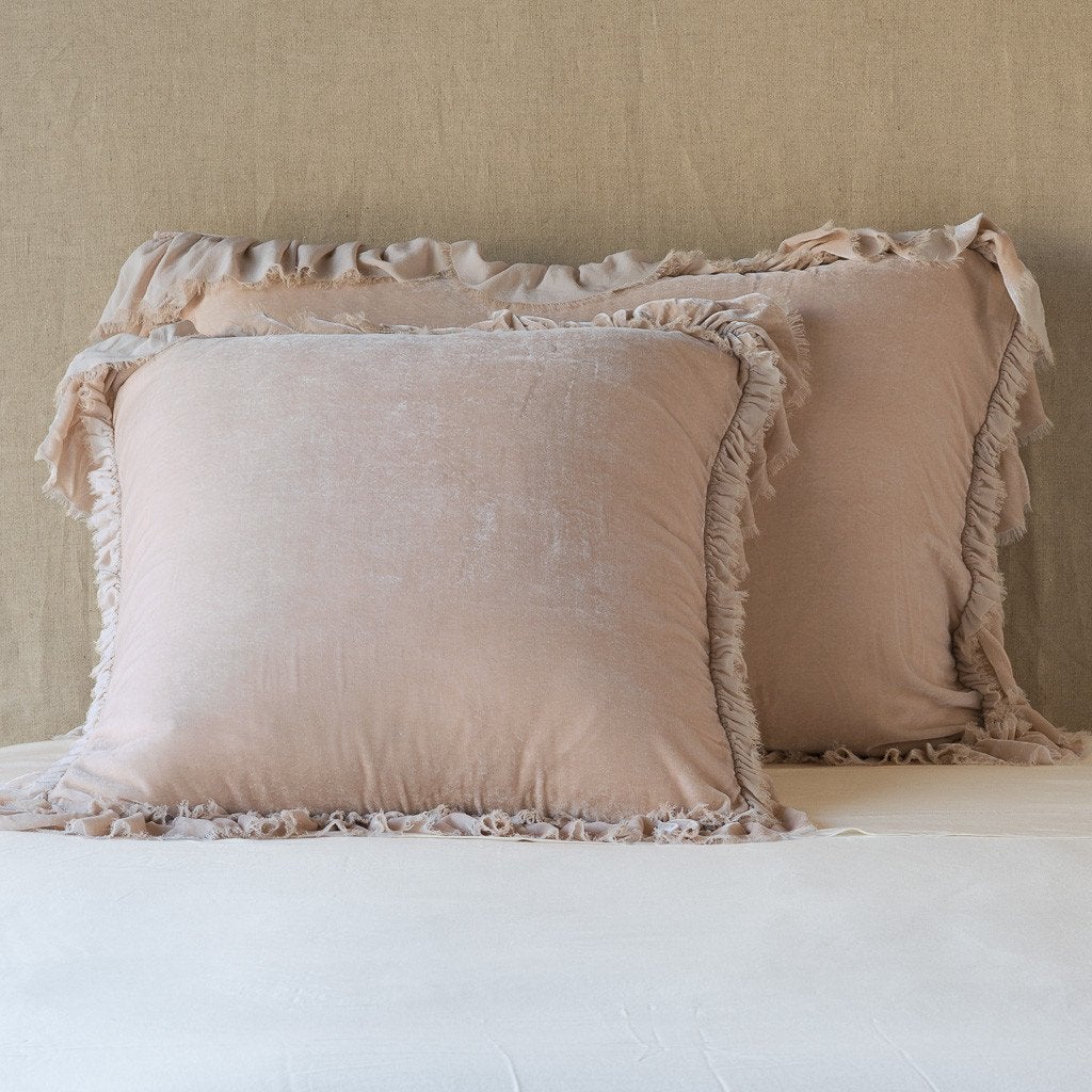 Pearl: shams leaning upright on white sheets against a neutral headboard.