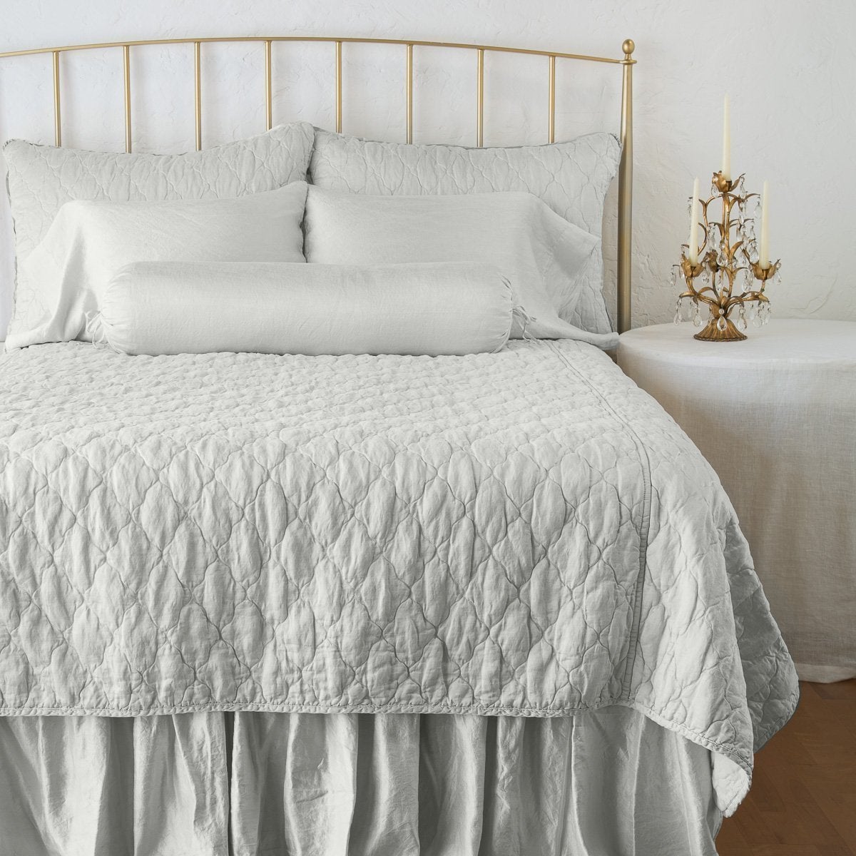 Sterling: shams on a shining, monochromatic bed with matching coverlet - end of bed view.