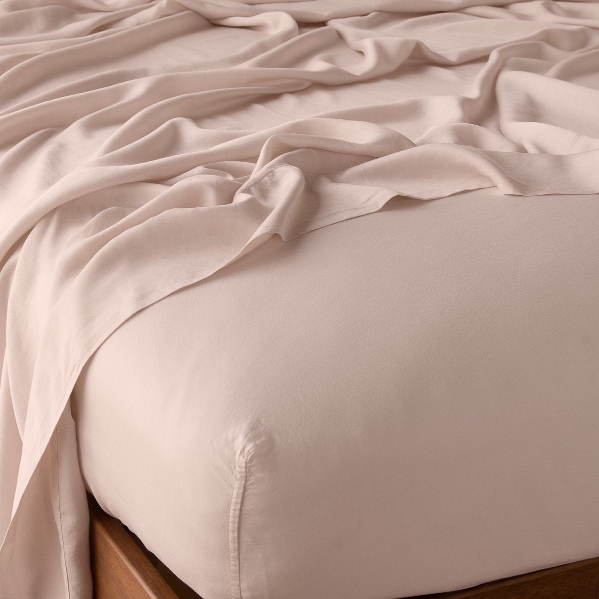 Rouge: fitted sheet with matching rumpled flat sheet - top corner view.