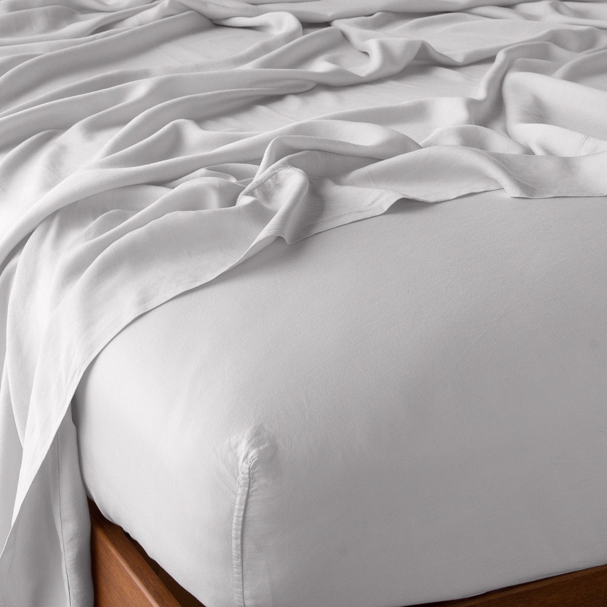 Sterling: fitted sheet with matching rumpled flat sheet - top corner view.